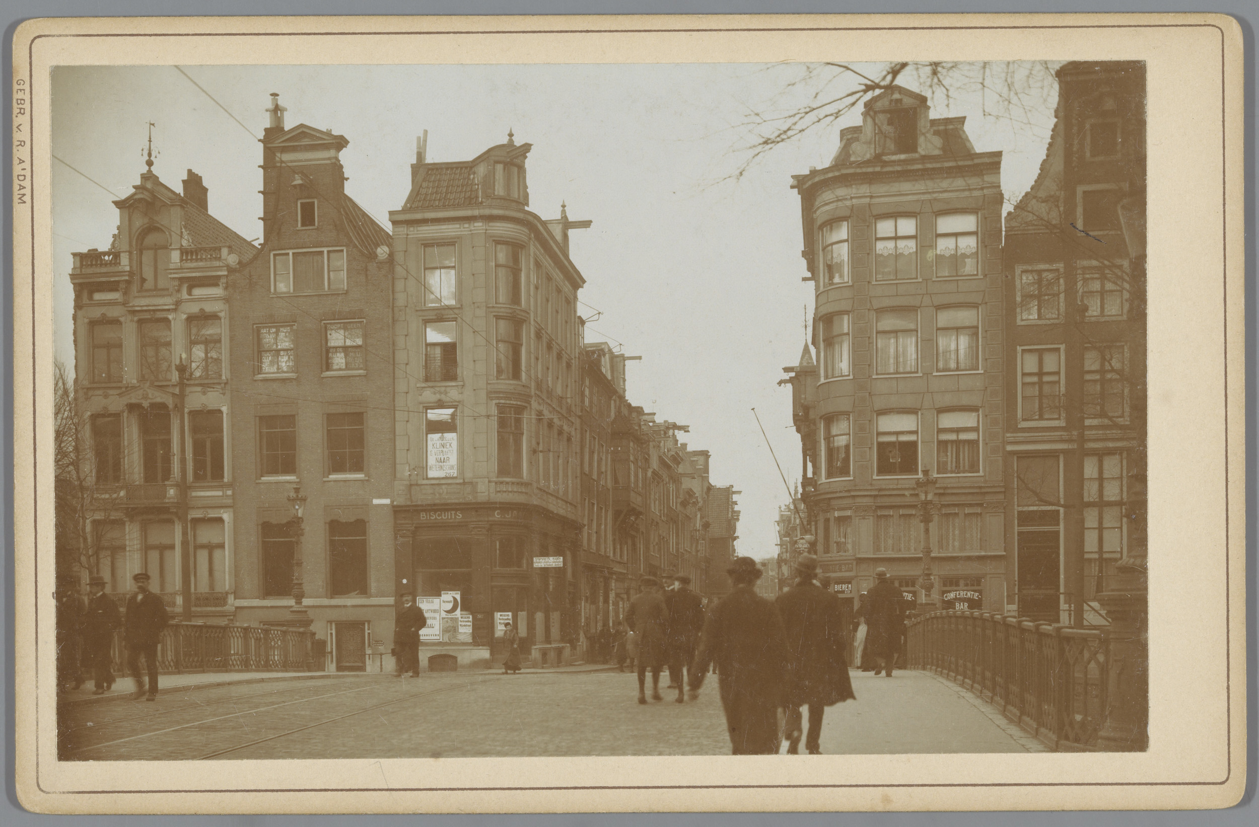 Landscape photograph by Gebr. van R. showing a street in Amsterdam with cobblestones and buildings.