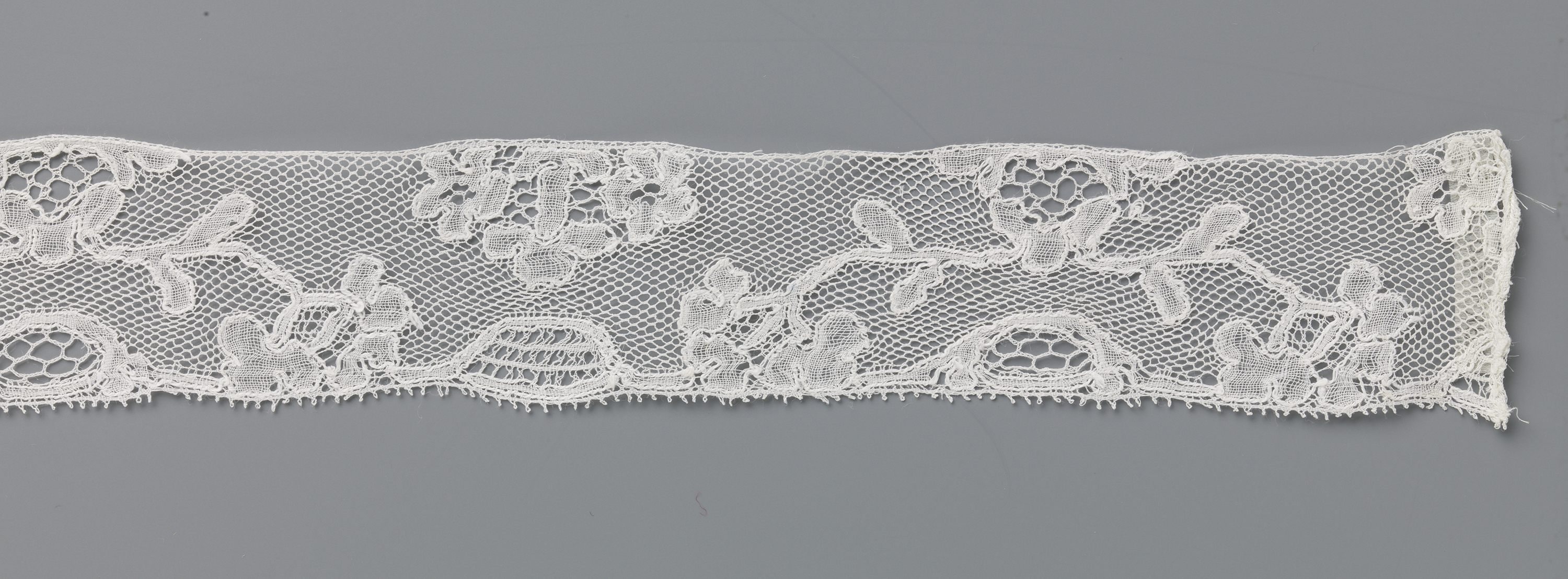 Lace work titled 'Strook kloskant met boogje van takken' by Unknown Artist