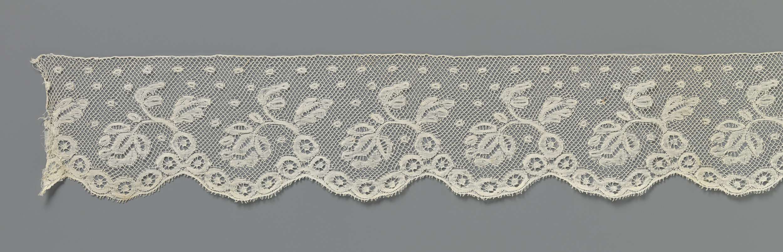 Lace textile art by Unknown Artist featuring floral patterns and intricate designs.