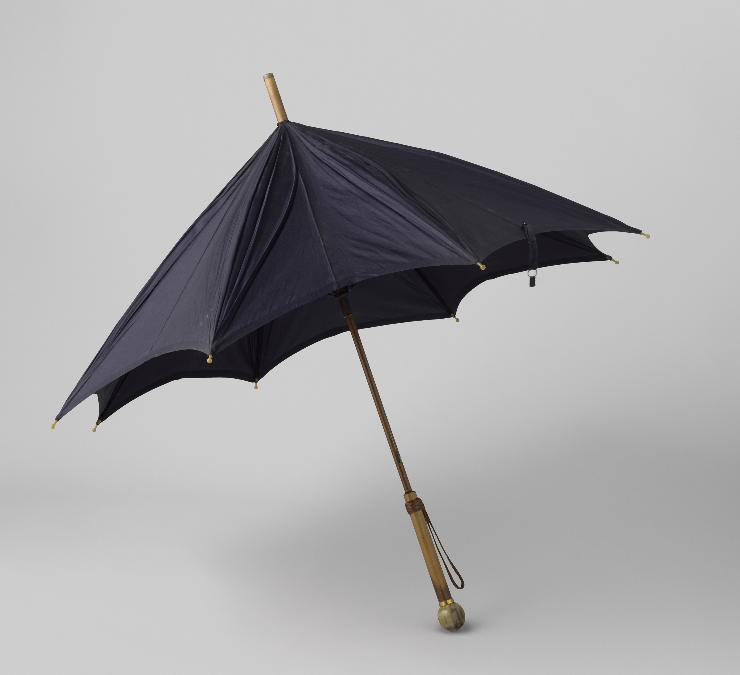 Dark blue silk umbrella with wooden handle and leather strap by Unknown Artist