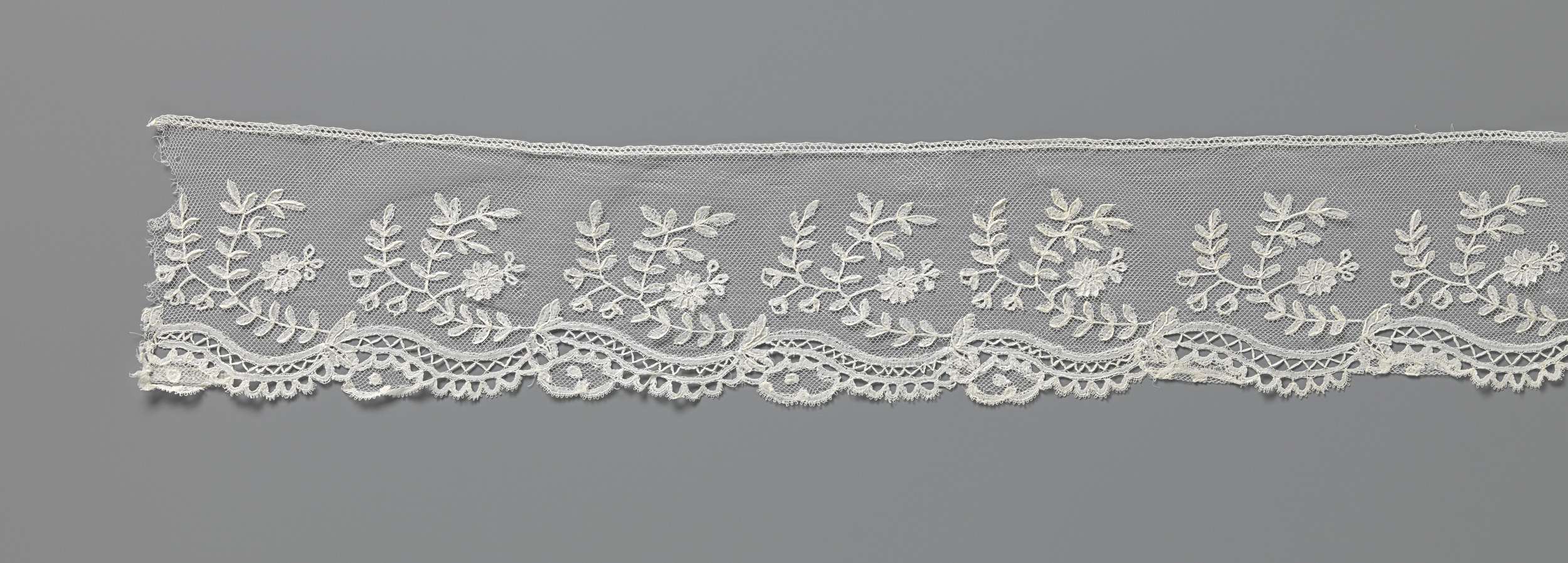 Lace artwork featuring a c-shaped flower branch by Unknown Artist