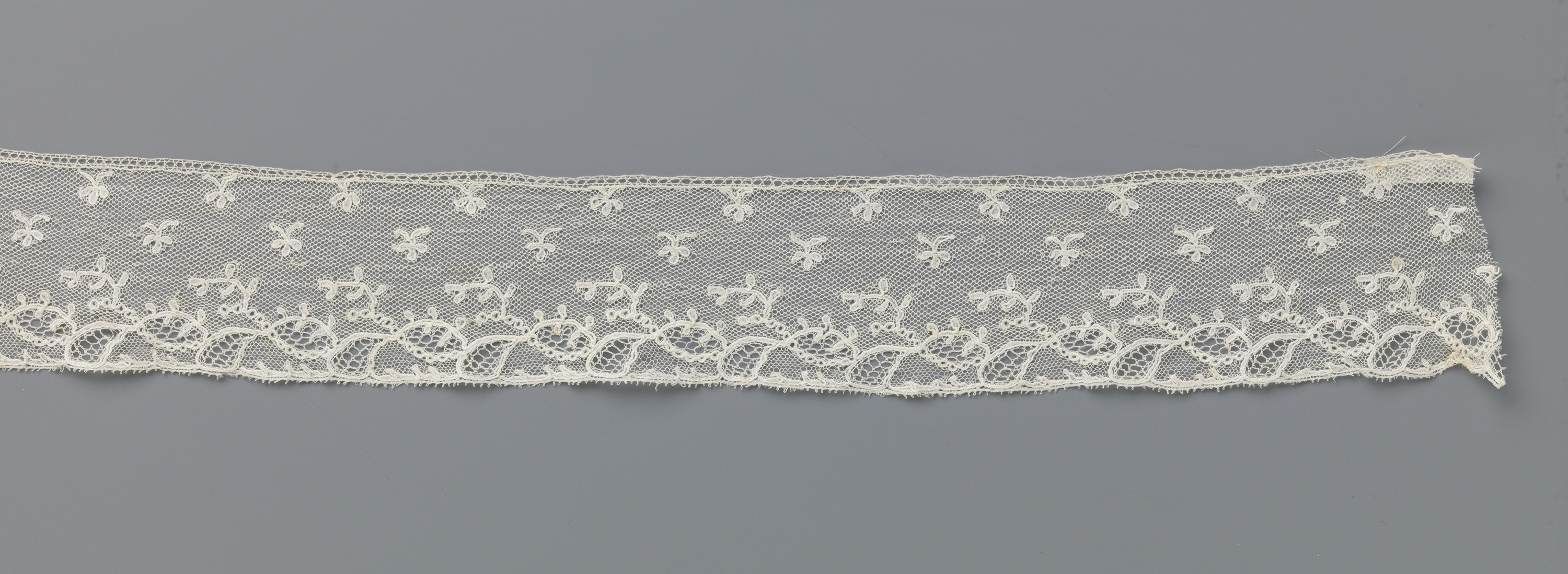 Lace textile by Unknown Artist featuring intricate patterns and oval forms