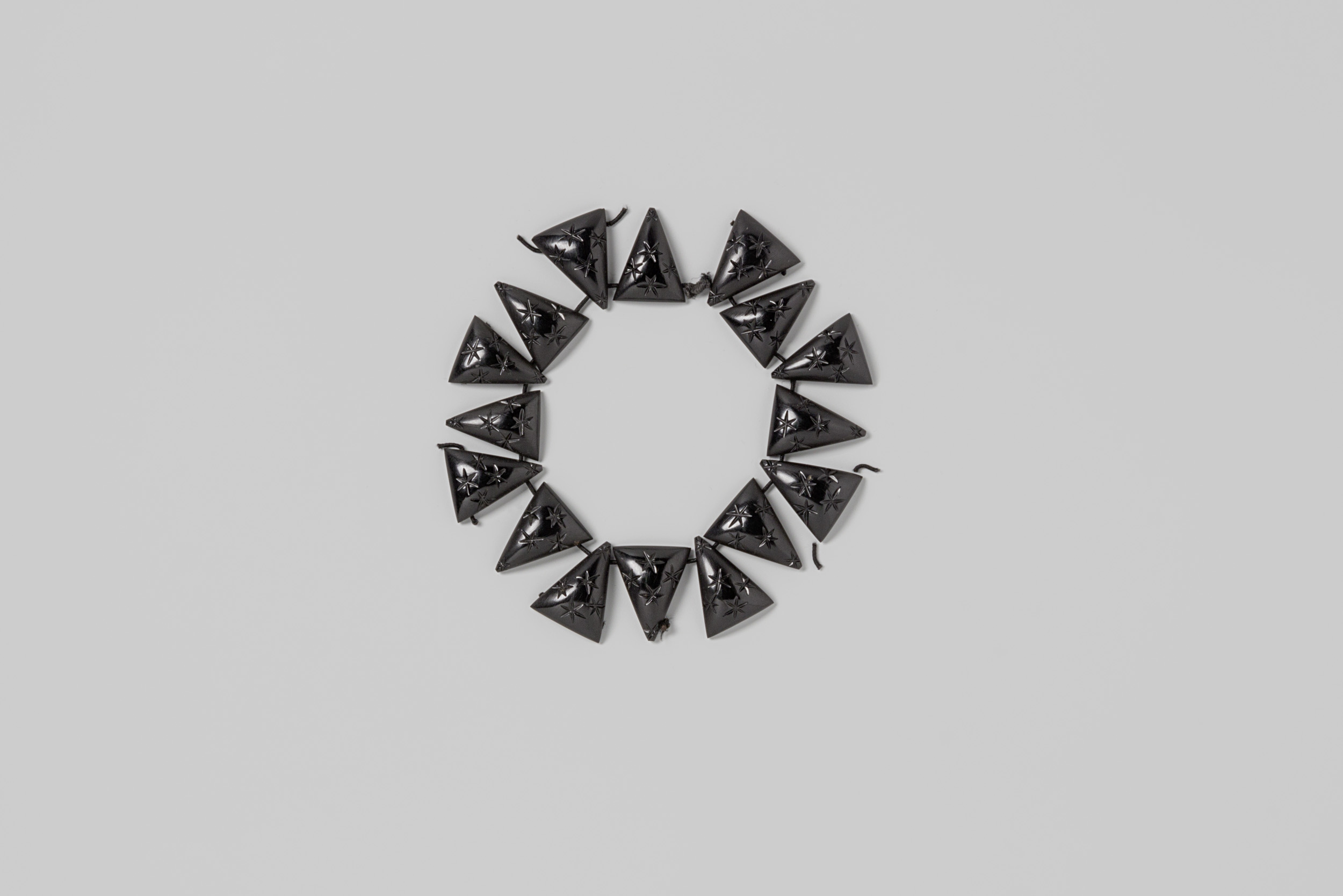 Armband met driehoekige schakels van zwart bakeliet, met elastiek bijeengehouden, by Unknown Artist, public domain