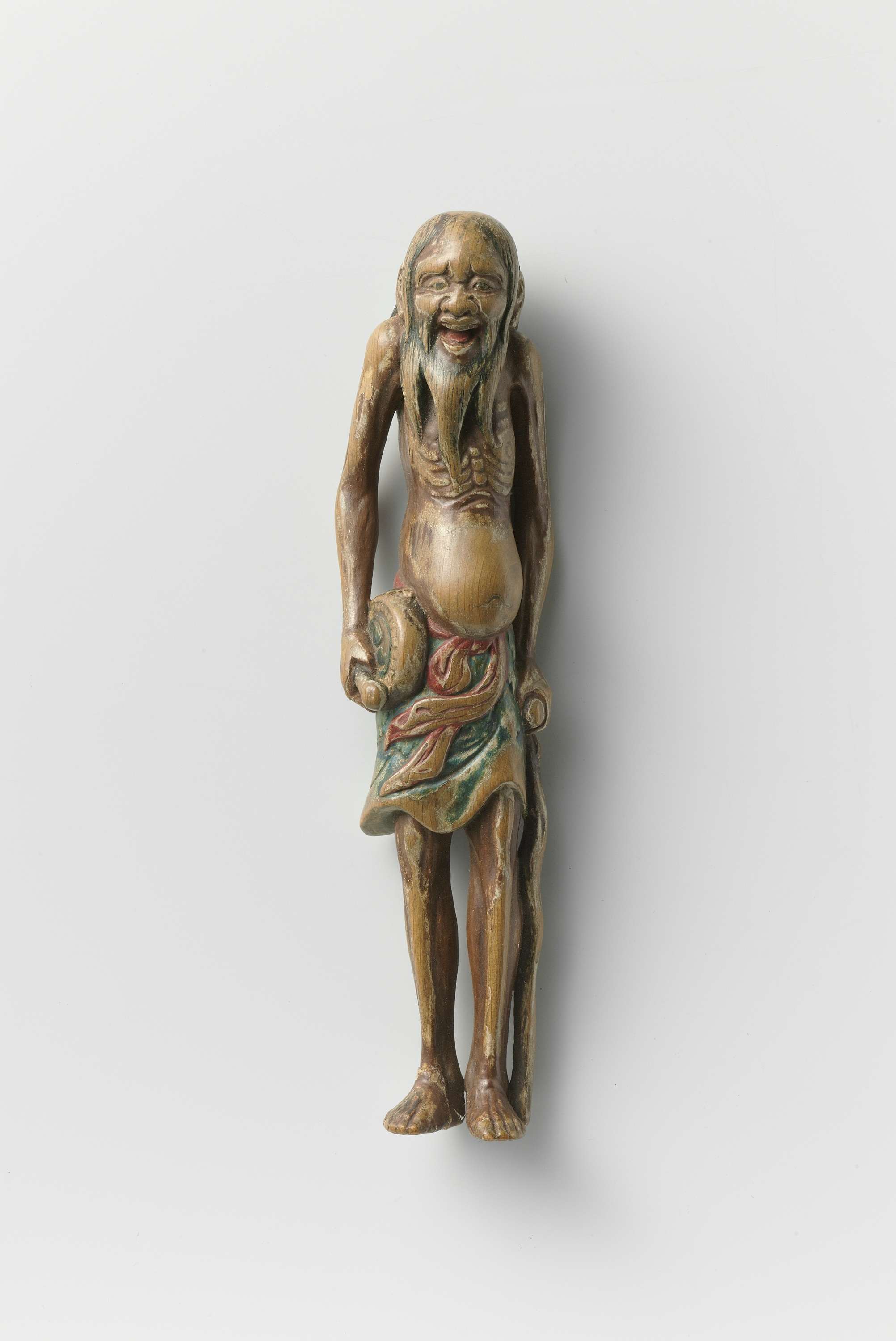Netsuke in the form of a holy man with a drum and staff, by Unknown Artist, public domain