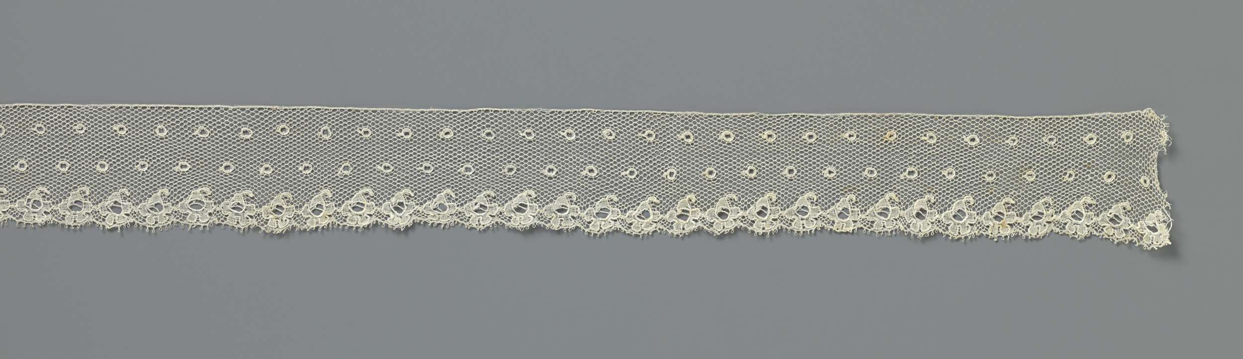 Delicate lace work titled 'Strook kloskant met moesjes en rozetrand' by Unknown Artist