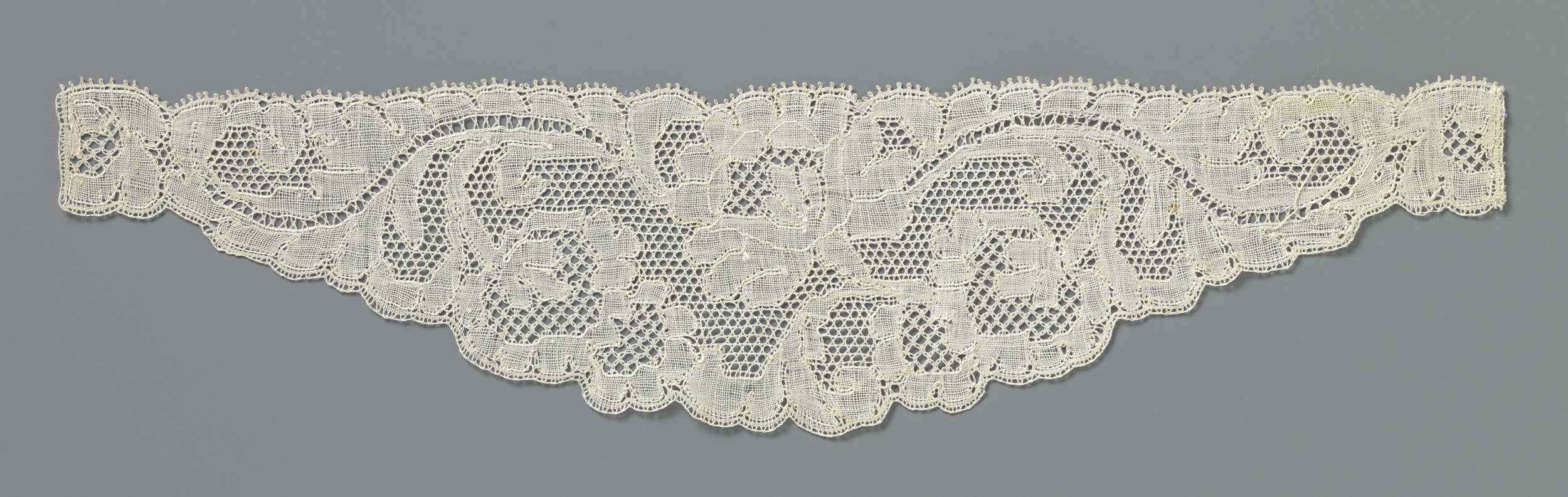 Lace textile by Unknown Artist featuring intricate floral patterns.
