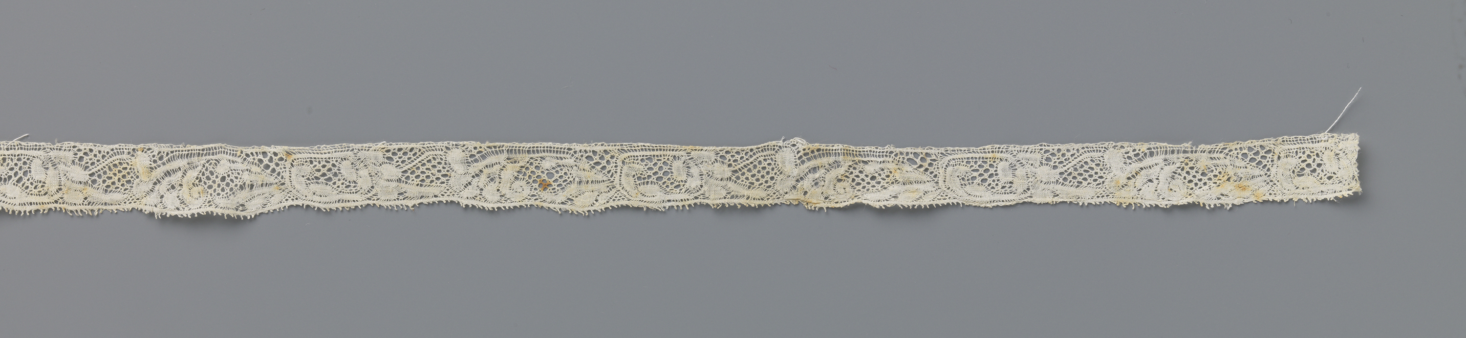 Lace artwork featuring a flower and curved stem by Unknown Artist