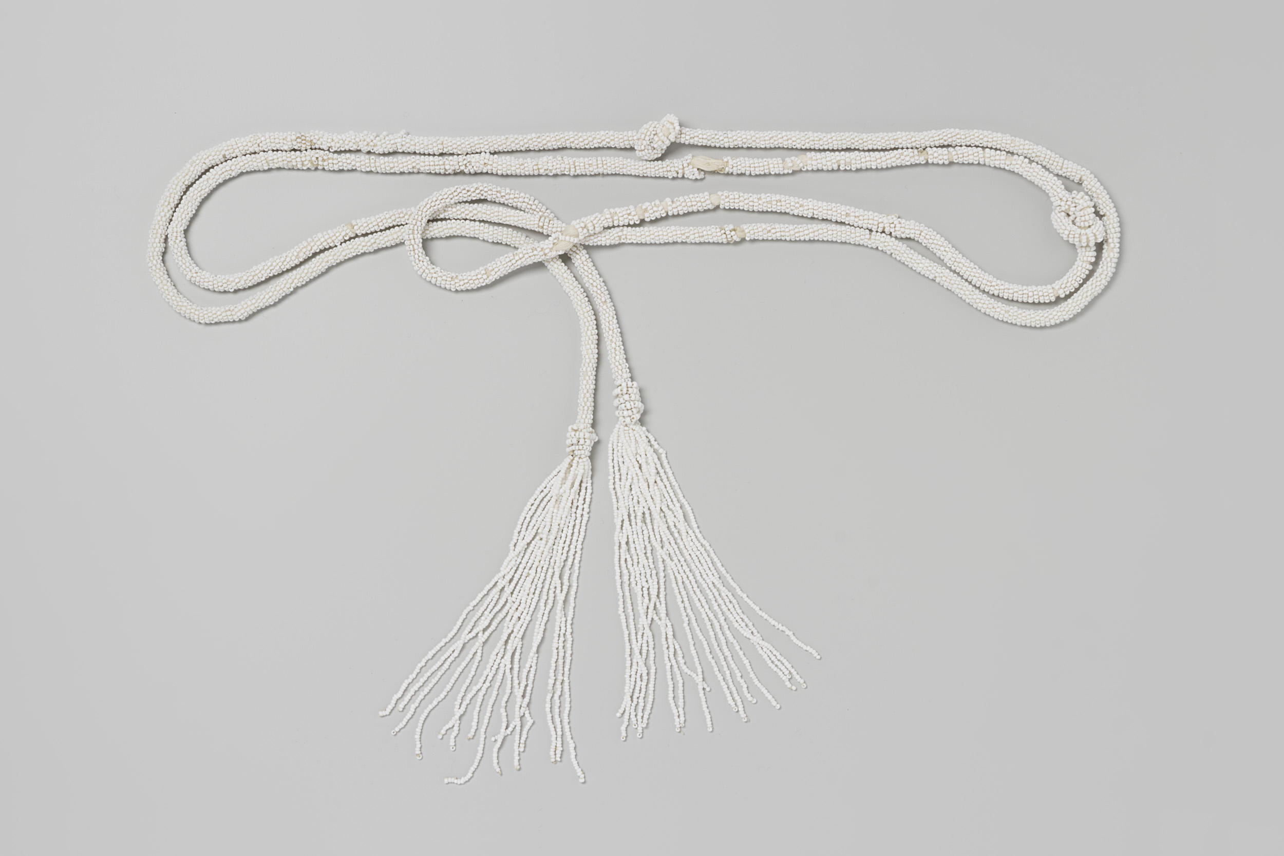 Decorative art piece featuring a long cord adorned with white beads by Unknown Artist