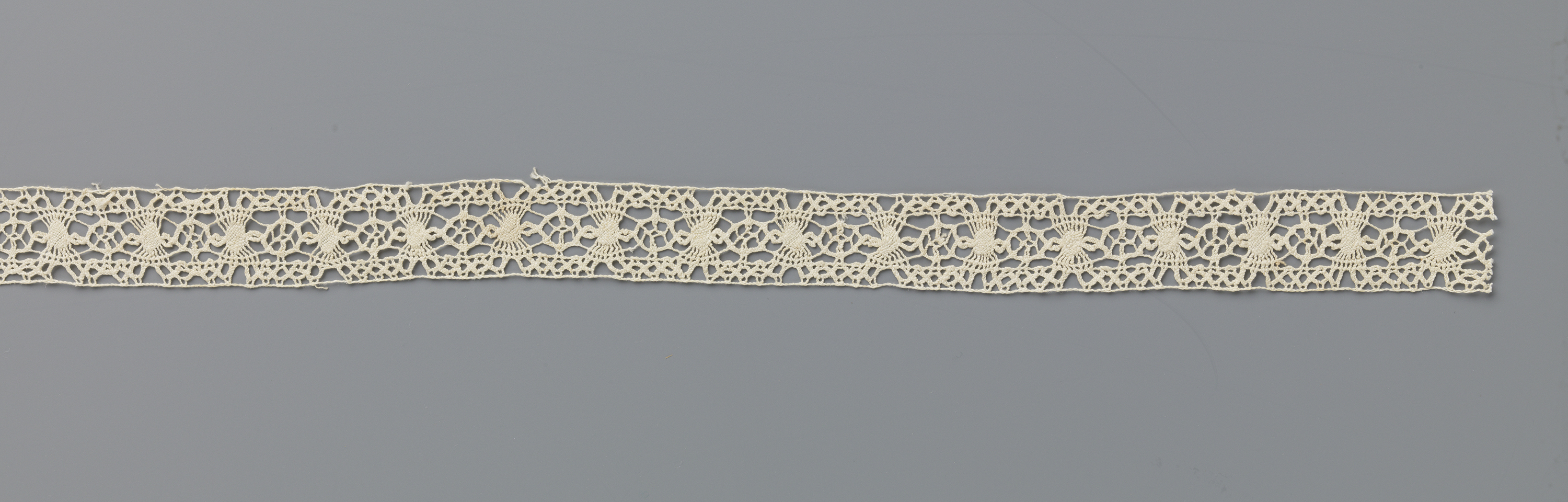 Lace work titled Tussenzetsel van kloskant met wieltjes en zonnetjes by Unknown Artist