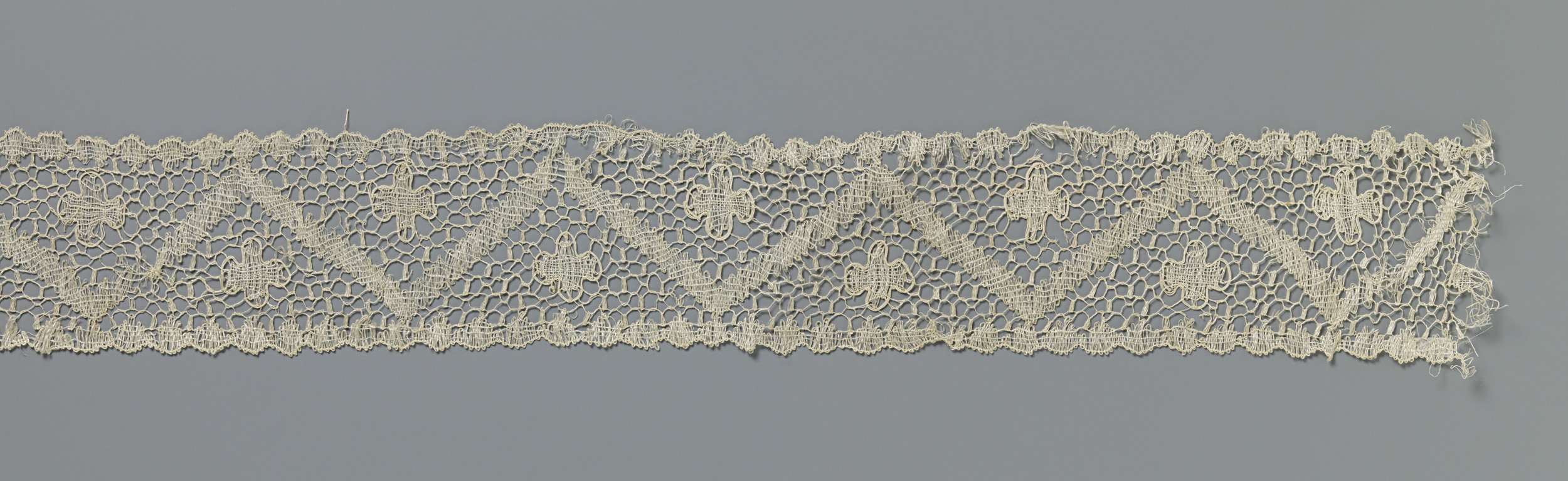 Strook kloskant met vierlobbig rozet boven en onder een zigzag-band, by Unknown Artist, public domain