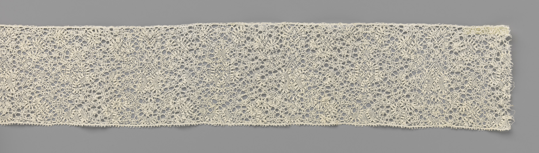 Lace artwork by Unknown Artist featuring human-like figures made of narrow ribbons.