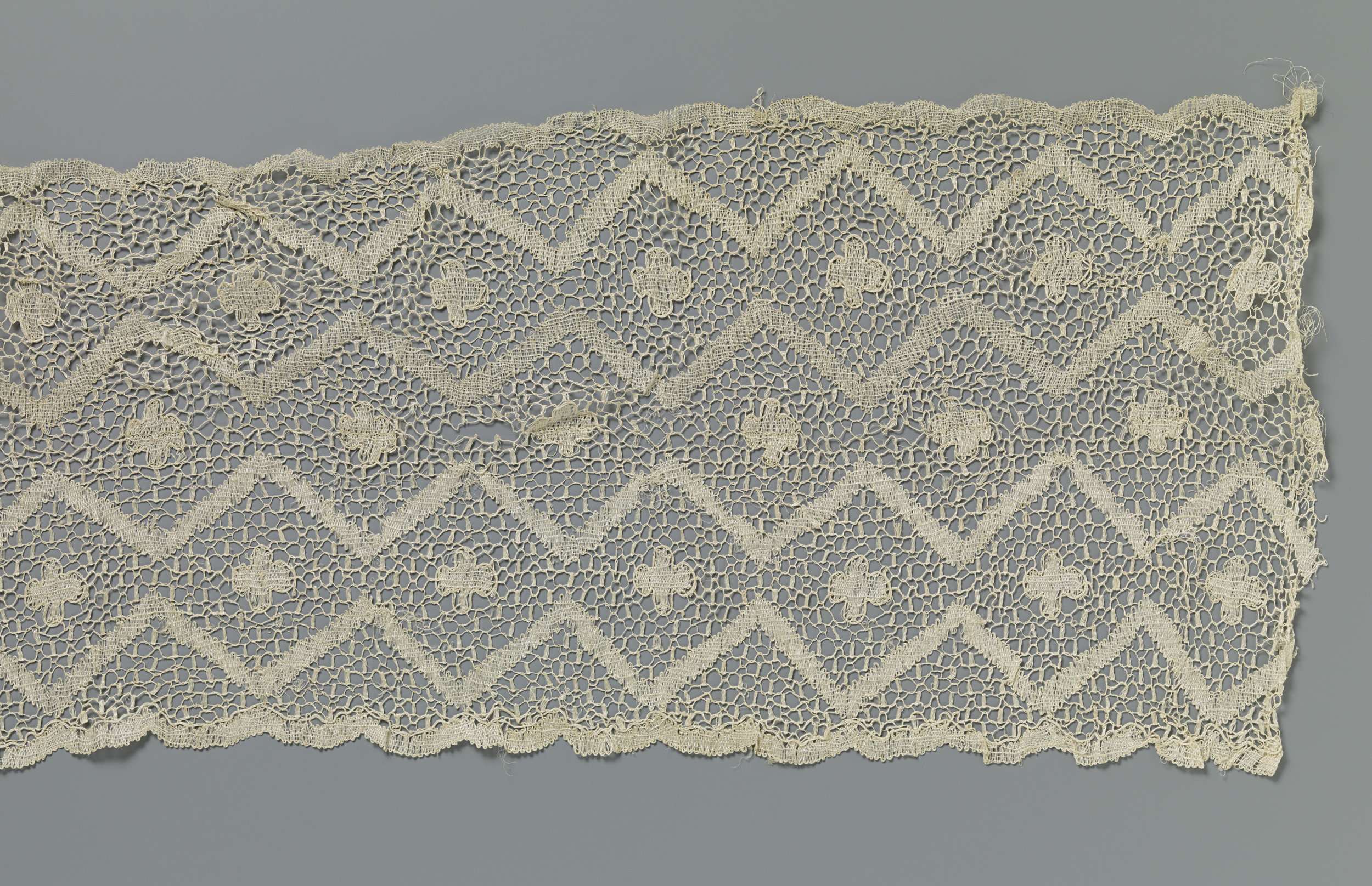 Lace textile art featuring intricate rosettes and zigzag patterns by Unknown Artist