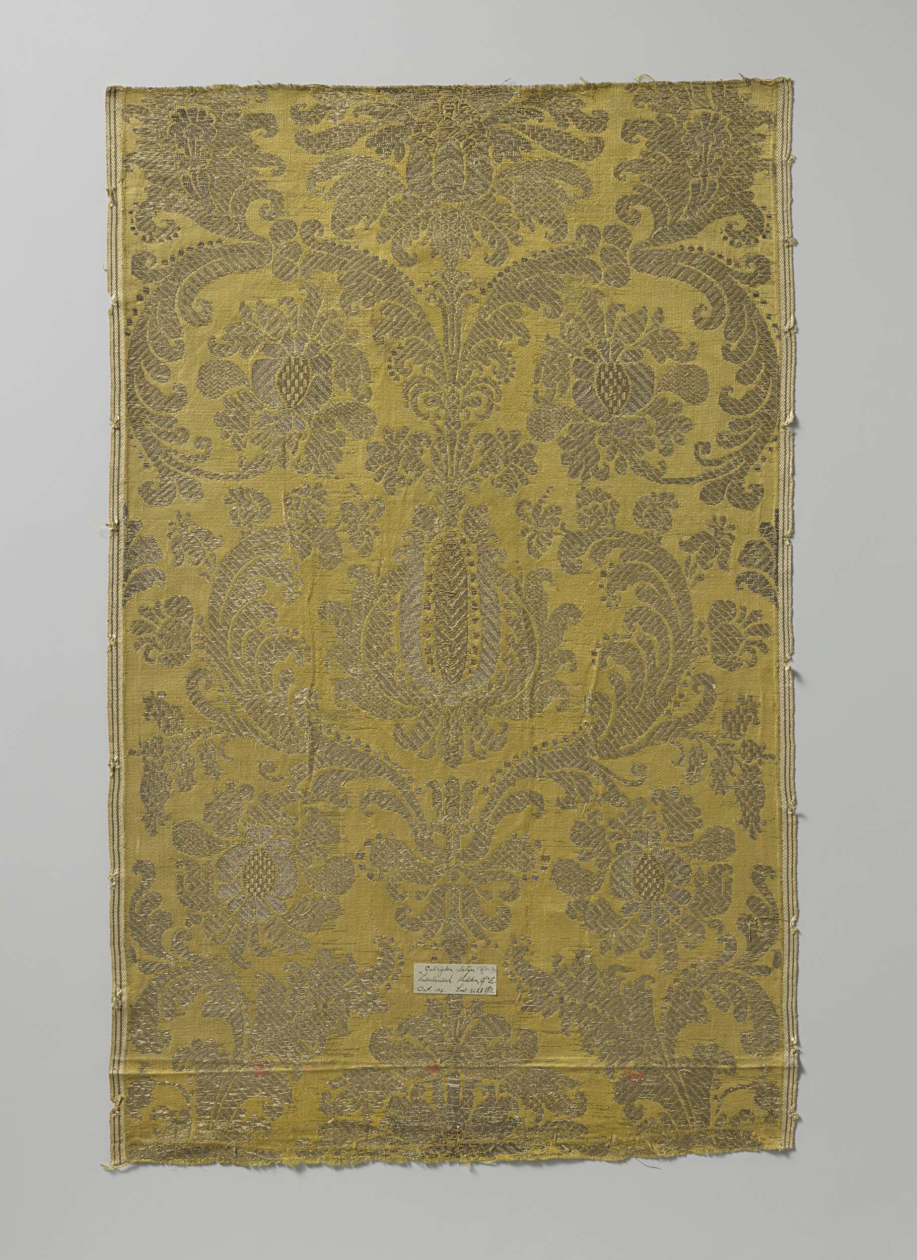 Fragment of brocade by Unknown Artist featuring floral motifs with gold and silver threads.
