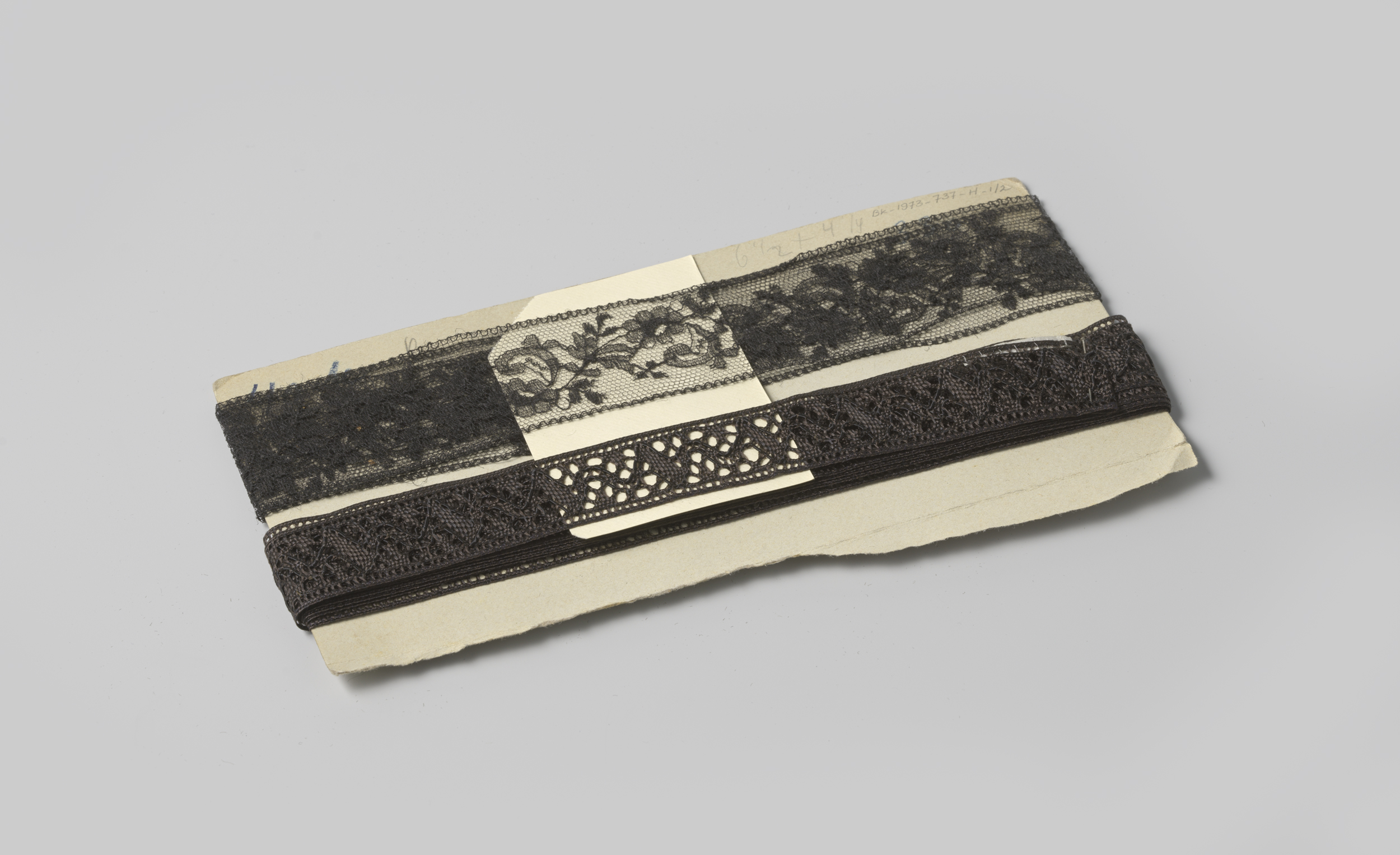Decorative textile by Gustav Schnitzler featuring floral and leaf motifs in black lace.