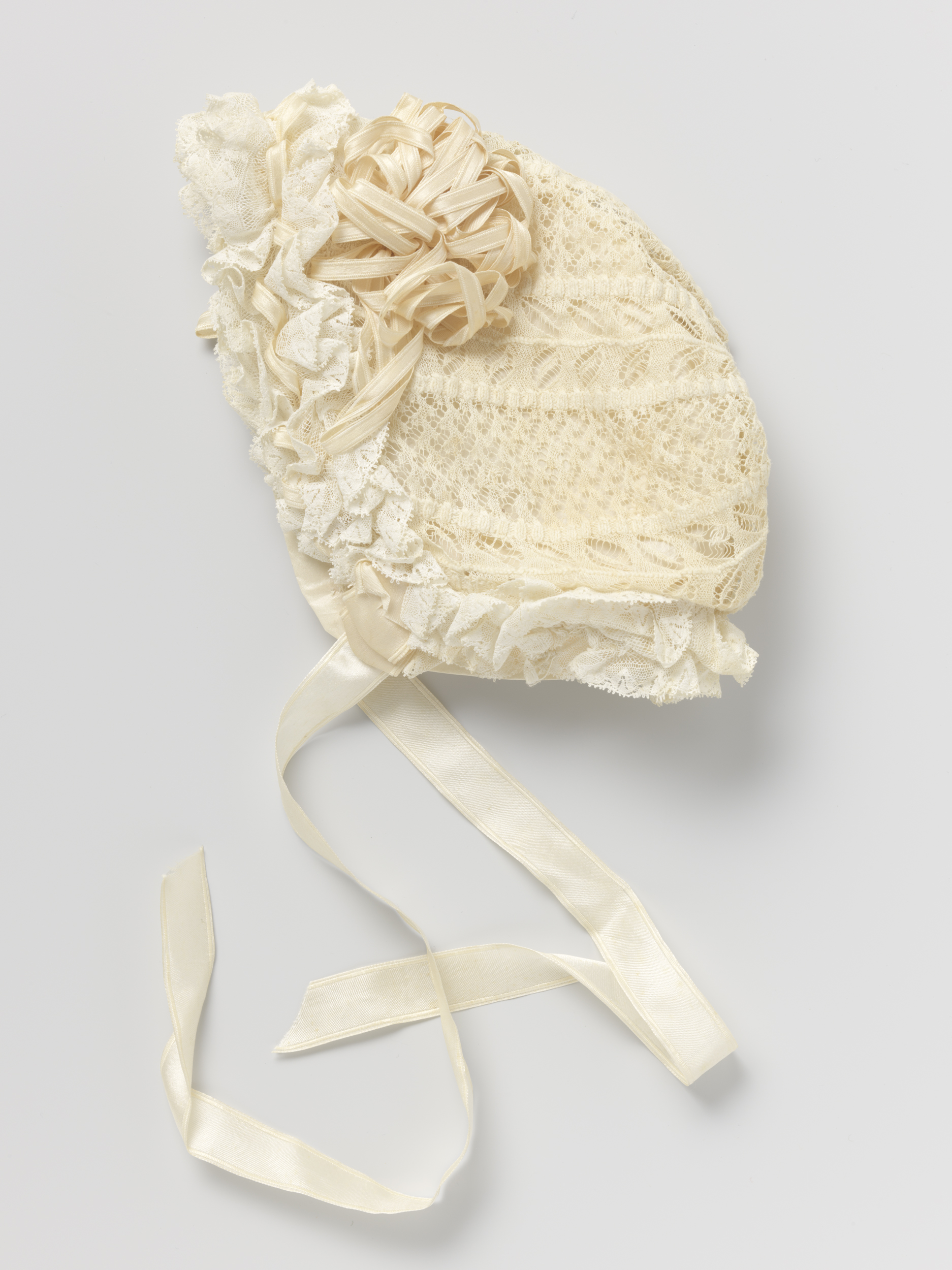 Victorian cotton cap with lacework and satin rosettes, unknown artist