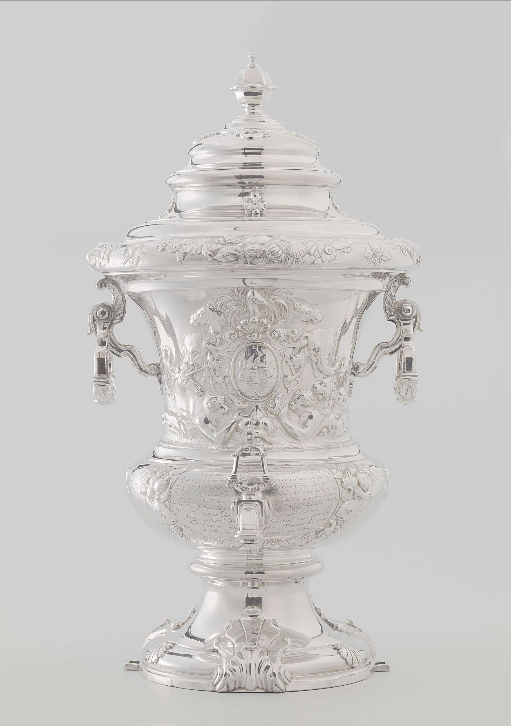 Wine fountain and cooler in metal by Alger Mensma, depicting naval trophies and decorative motifs.