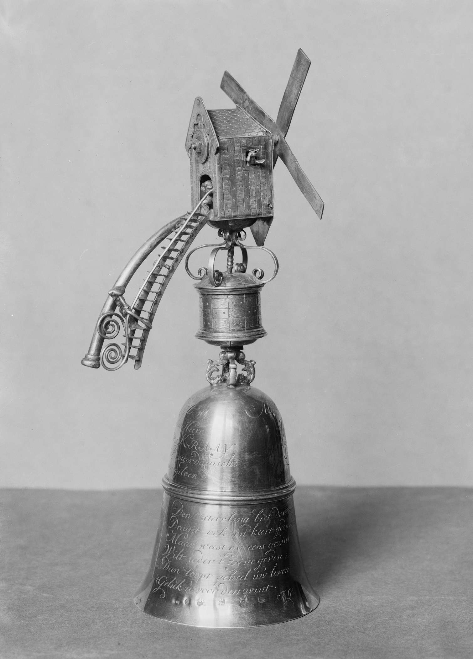 Gilded metal beaker by Hendrik van Beest, resting on a wooden table
