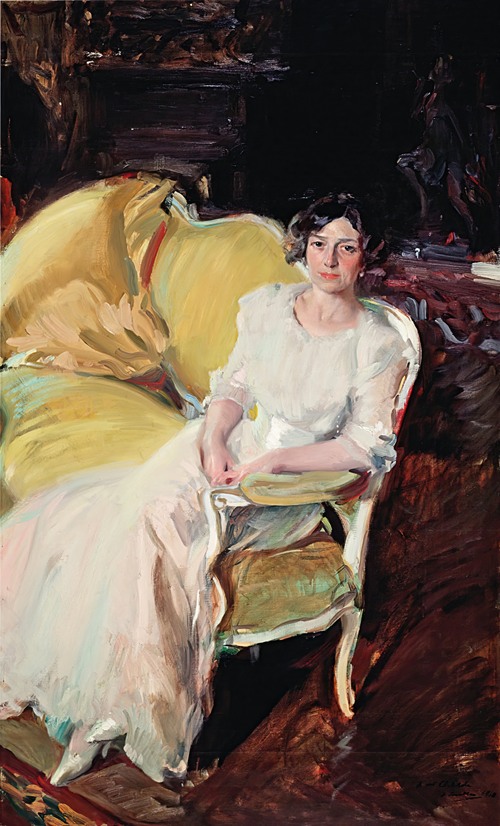 A portrait of a woman seated on a sofa, showcasing vibrant colors and intricate details.