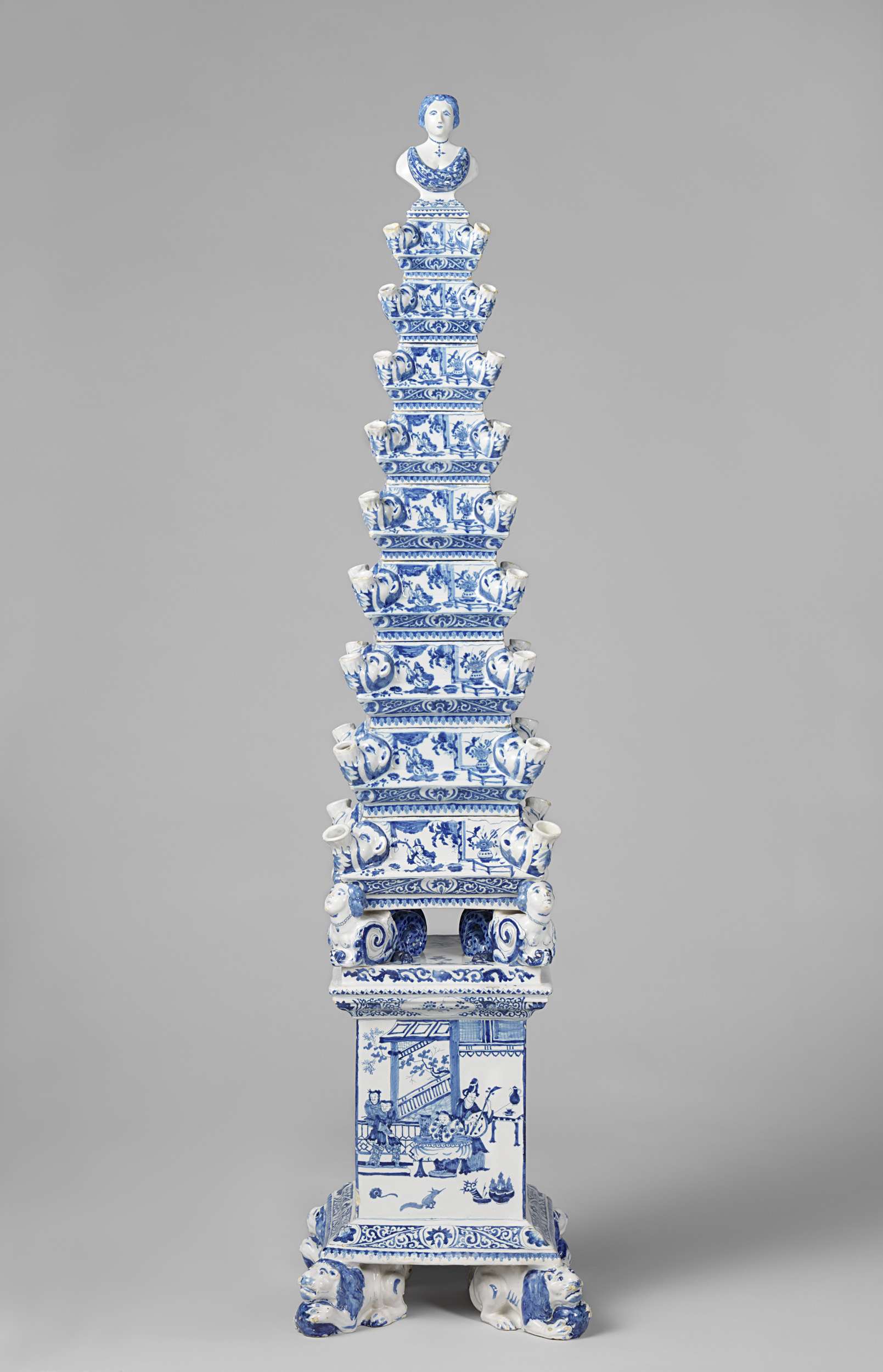 Flower pyramid in paint by De Metaale Pot, featuring a tall stacked vase with flowers.