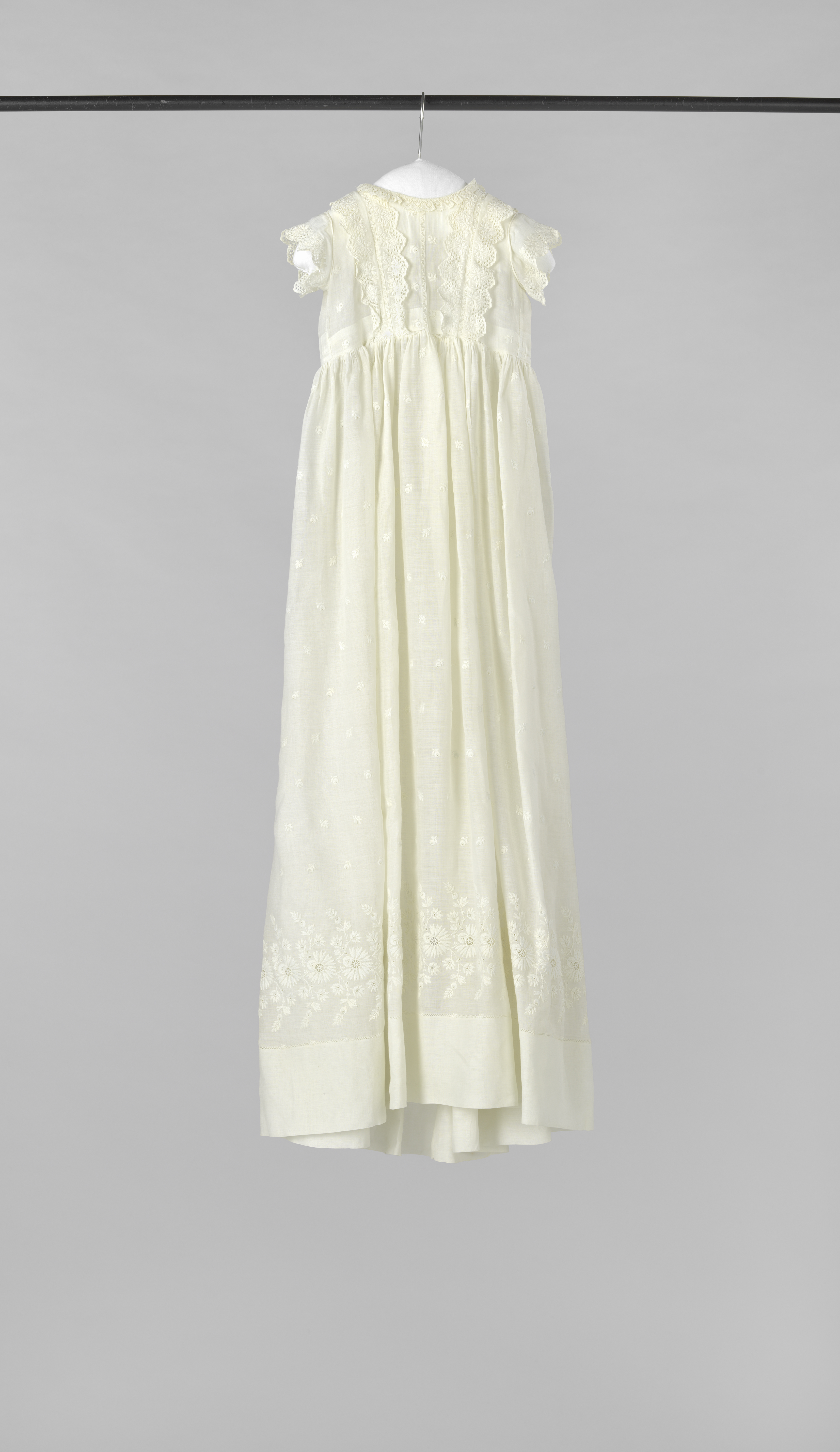 Textile garment for a baby by Unknown Artist featuring embroidery of cornflowers and roses.