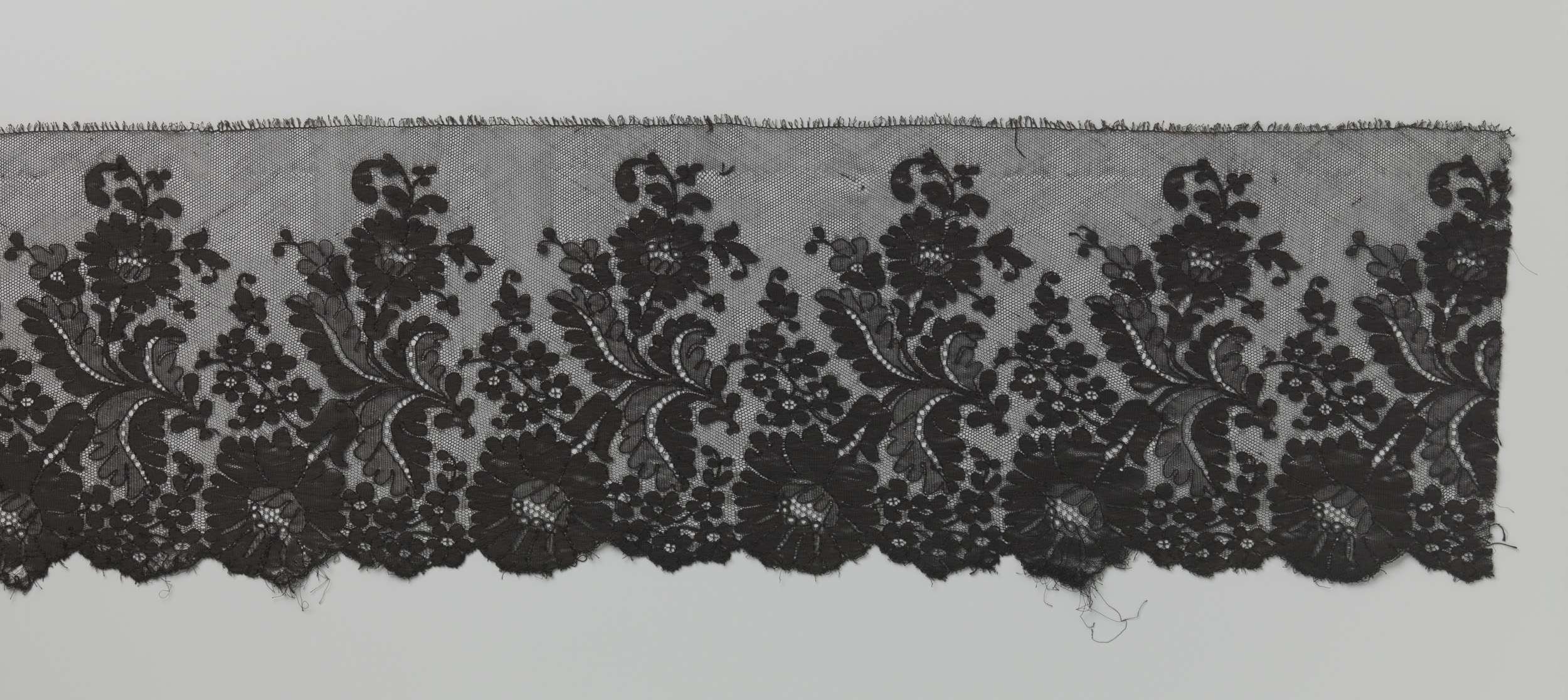 Lace artwork by Unknown Artist featuring a large hanging flower in soft hues.