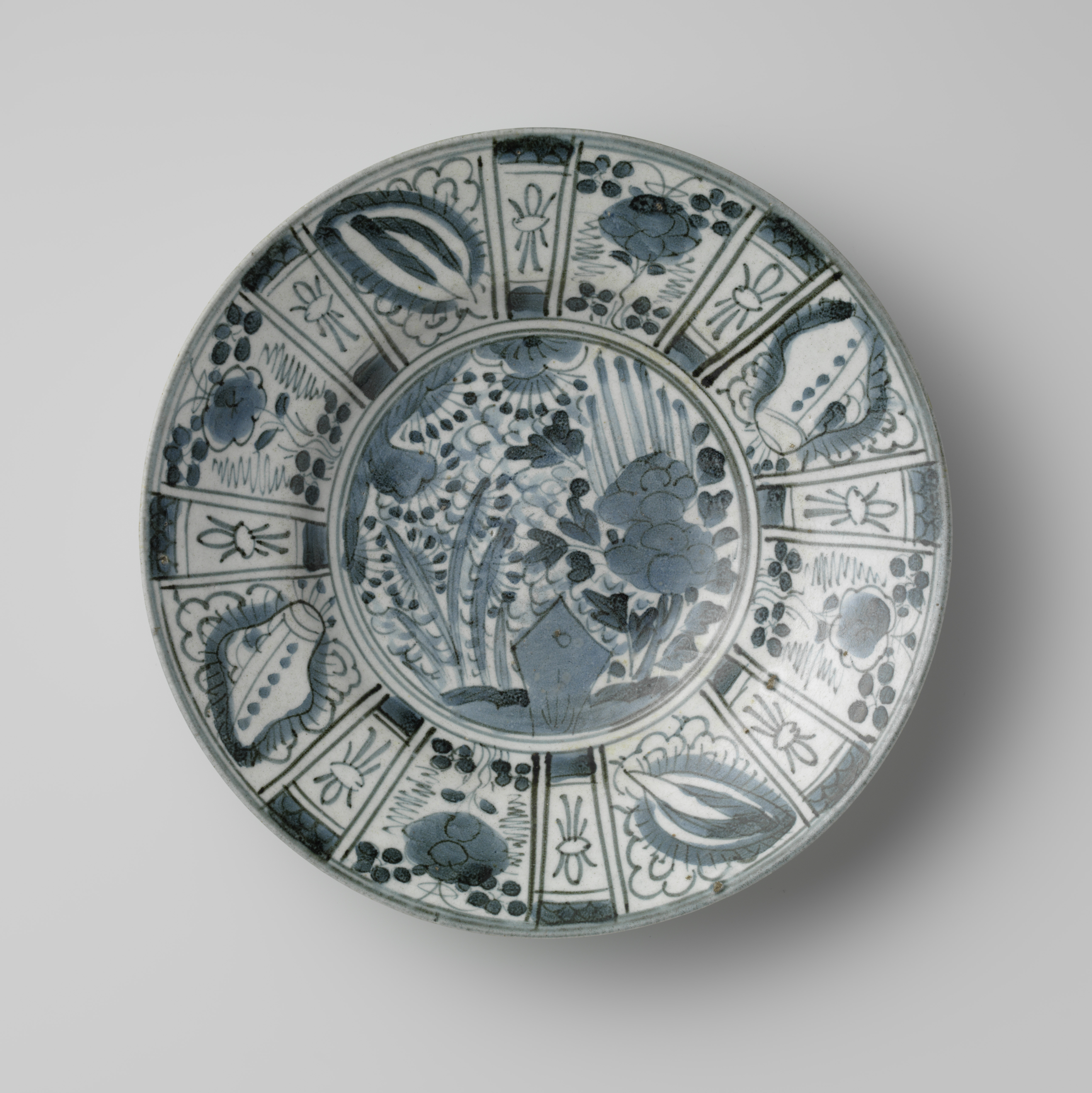 Ceramic plate by Unknown Artist, featuring dark blue kraak glaze.