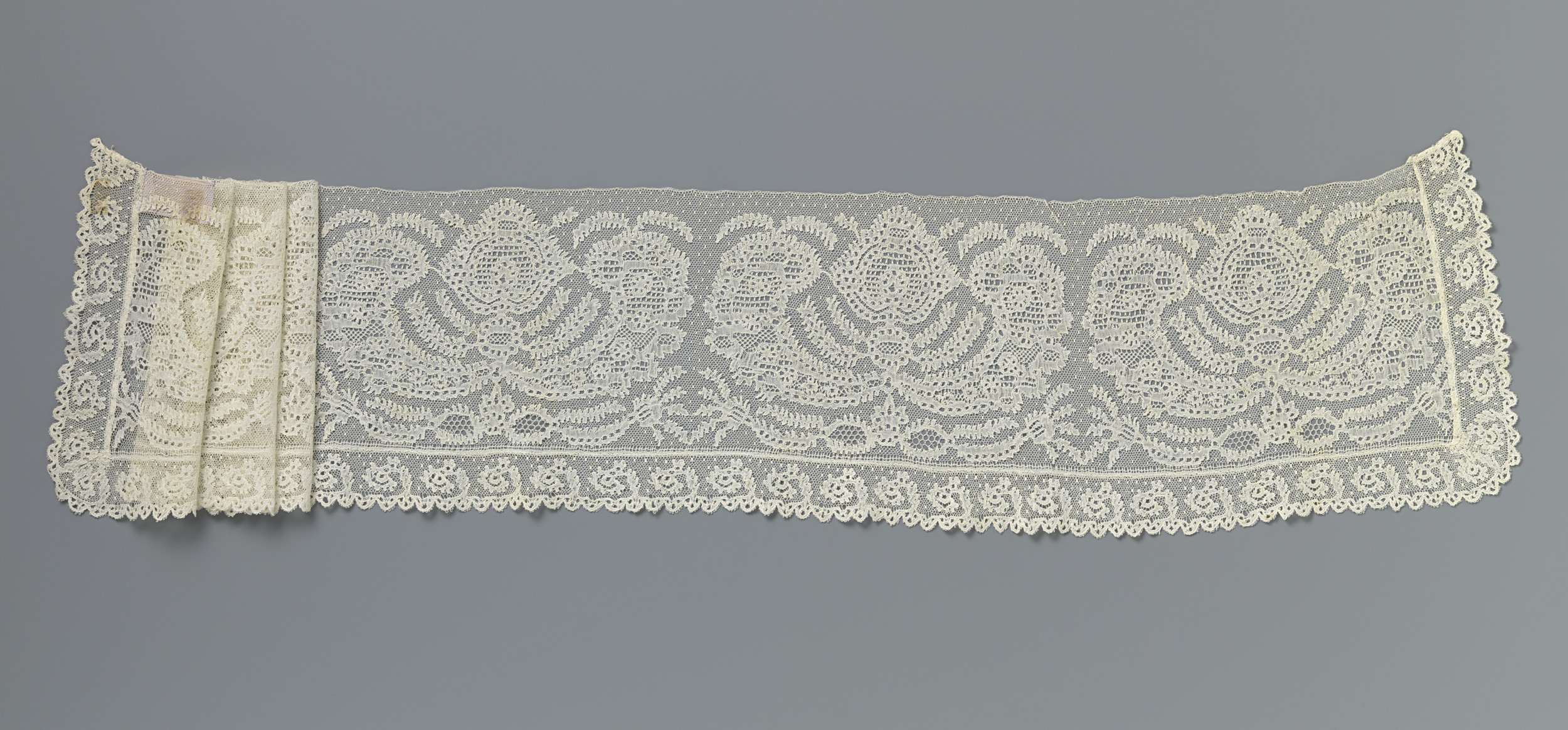 Lace textile work featuring a stylized flower and C-volutes by Unknown Artist