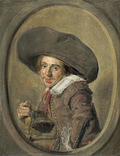 A young man wearing a large hat and a dark outfit is looking directly at the viewer.
