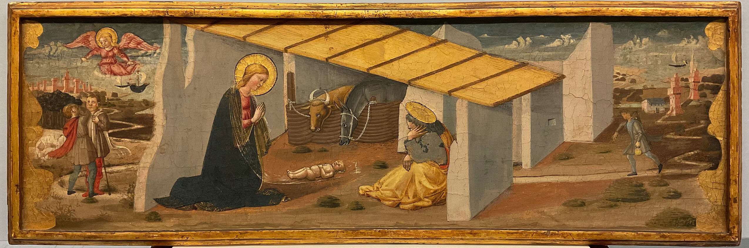 Nativity scene in wood by Neri di Bicci, featuring Mary and gathered figures in a stable.
