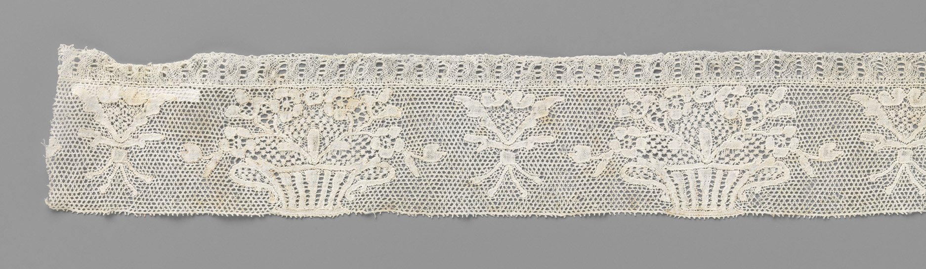 Still life of lace, a striped ceramic pot, and flowers by Unknown Artist