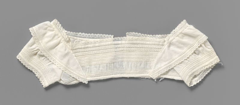 Peça têxtil de artista desconhecido apresentando um vestido de bebê bordado de c. 1830