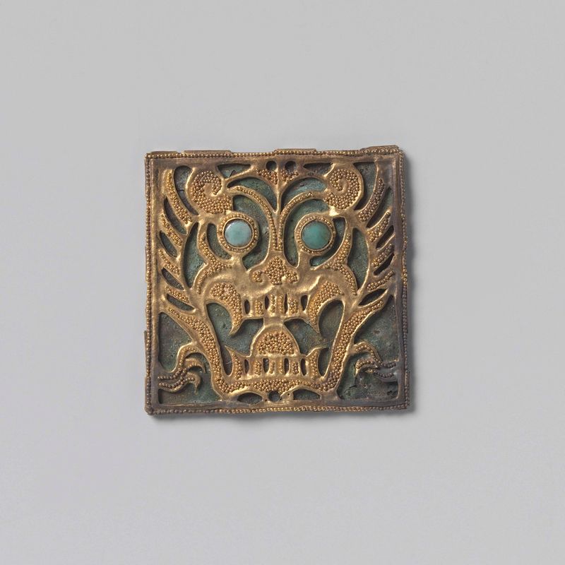 Ornamento de Vestuário, metal de Artista Desconhecido, com padrões intrincados e sombras.