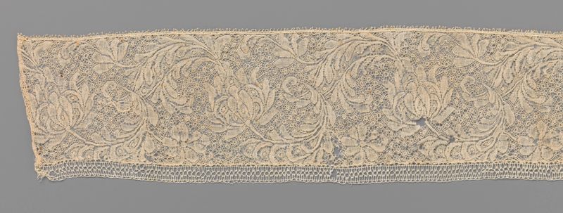 Obra de renda de Unknown Artist representando uma flor e uma folha em forma de C.