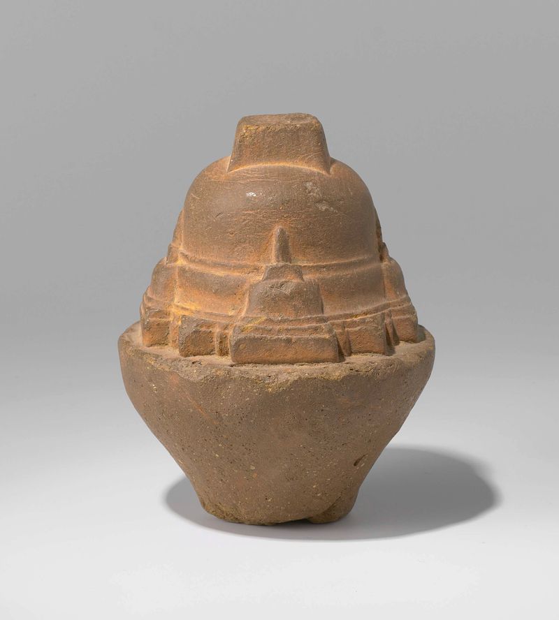 Estupa de terracota de un artista desconocido, mostrando detalles intrincados y diseño antiguo.
