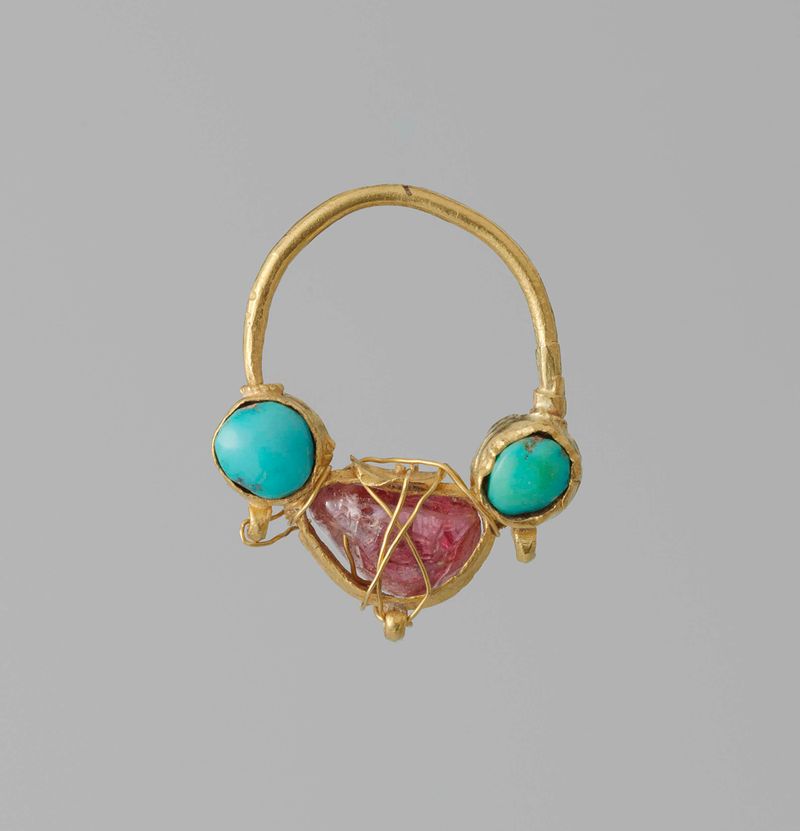 Ornamento de metal para la oreja de artista desconocido, con diseños intrincados y artesanía.