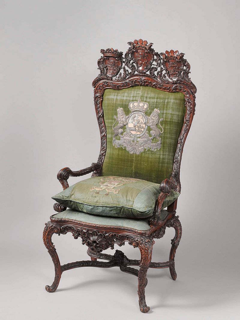 Silla de madera rococó de Gerrit Hutte con intrincadas tallas y escudo de armas.