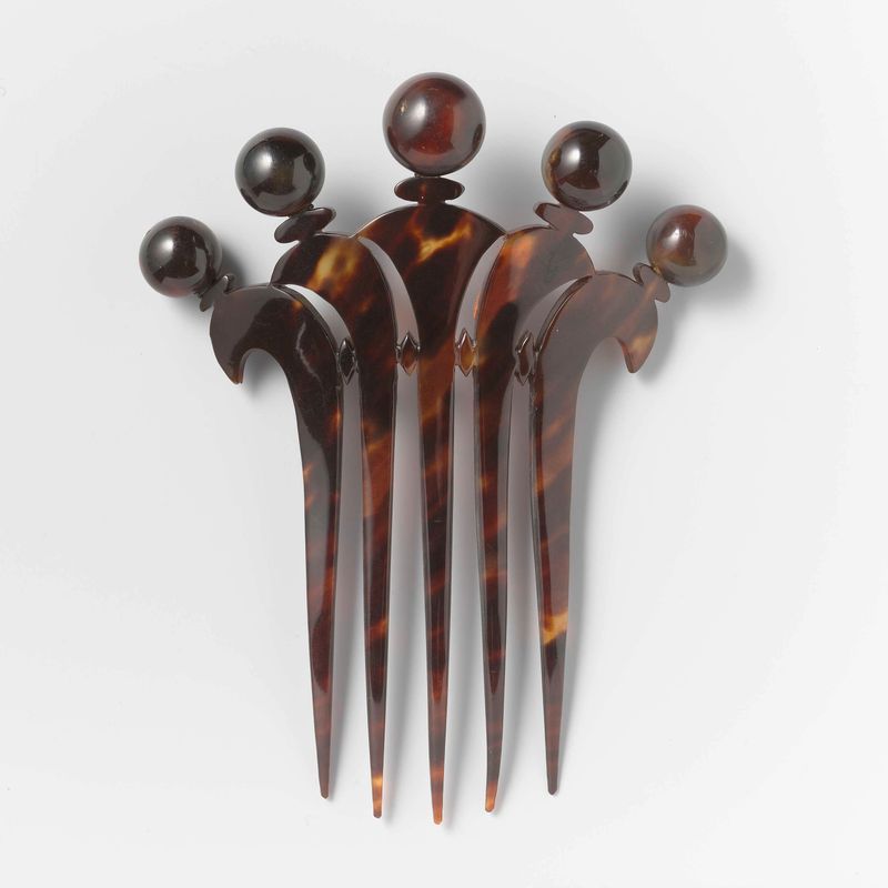 Pente decorativo de tartaruga por Unknown Artist, exibindo design e artesanato intrincados.