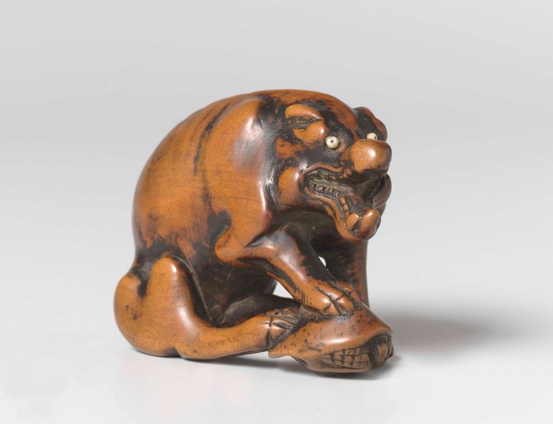 Netsuke of a wolf and turtle, wood sculpture by Tomotada