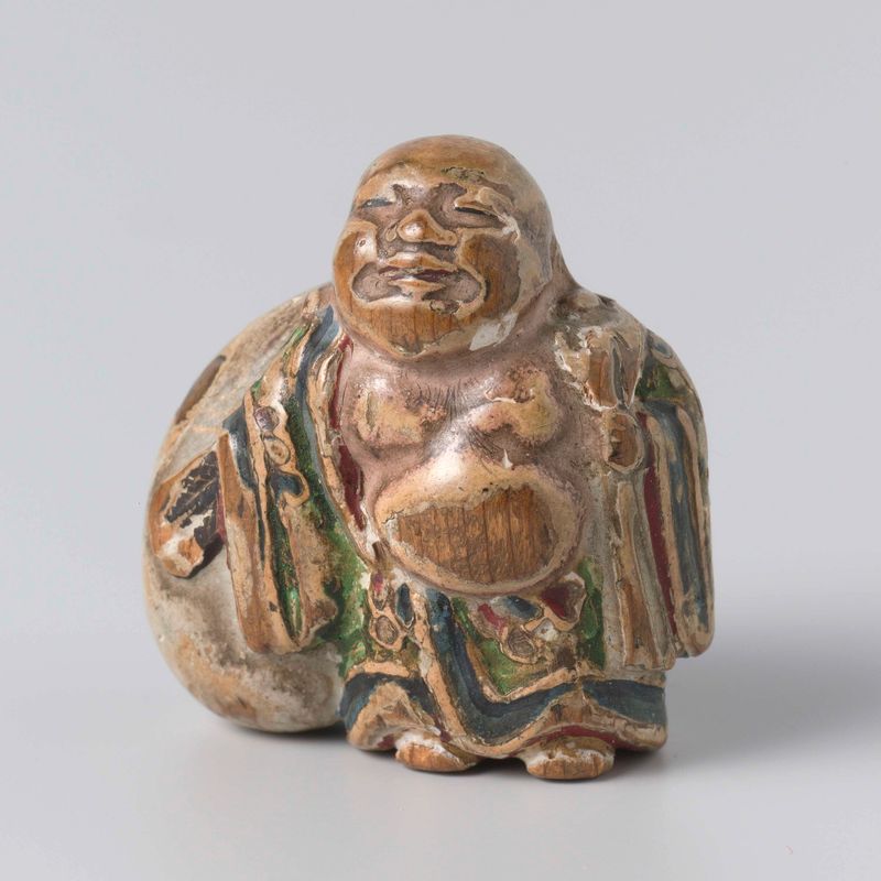 Netsuke de artista desconhecido, escultura em madeira com detalhes intrincados e figuras pequenas.