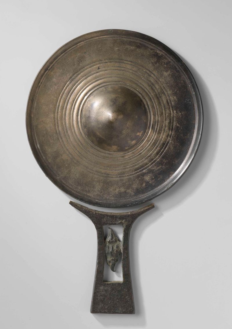 Arte decorativo de bronce de un artista desconocido que representa un espejo con reflejos de luz.