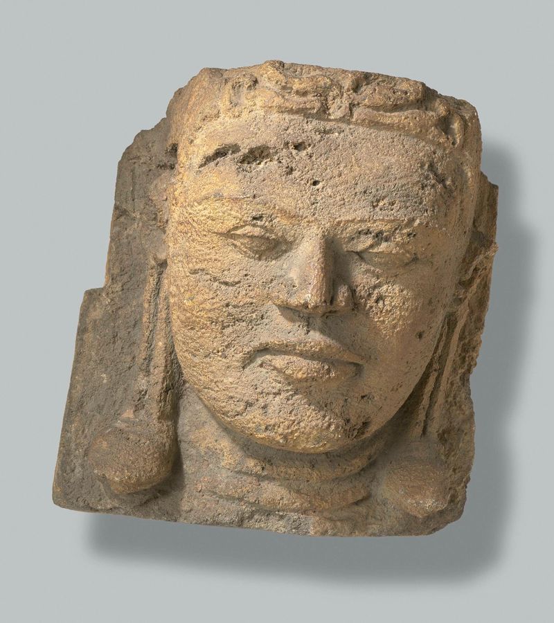 Escultura de piedra de una cabeza de Candi Bima por un artista desconocido