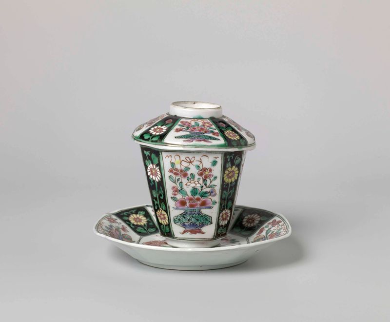 Taza y platillo de porcelana cubiertos con motivos florales de un artista desconocido