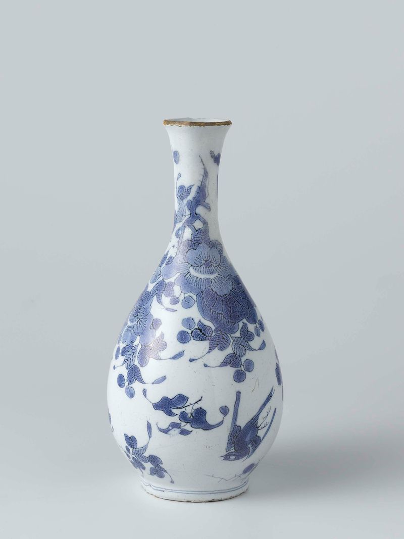 Still life of a white earthenware vase with colorful flowers by Het Moriaanshooft