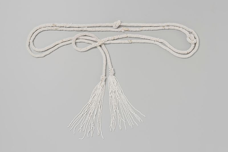 Obra de arte decorativa con un cordón largo adornado con cuentas blancas de artista desconocido