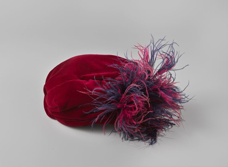 Peça de arte decorativa com um chapéu de veludo vermelho escuro com penas de Chapeau Erian