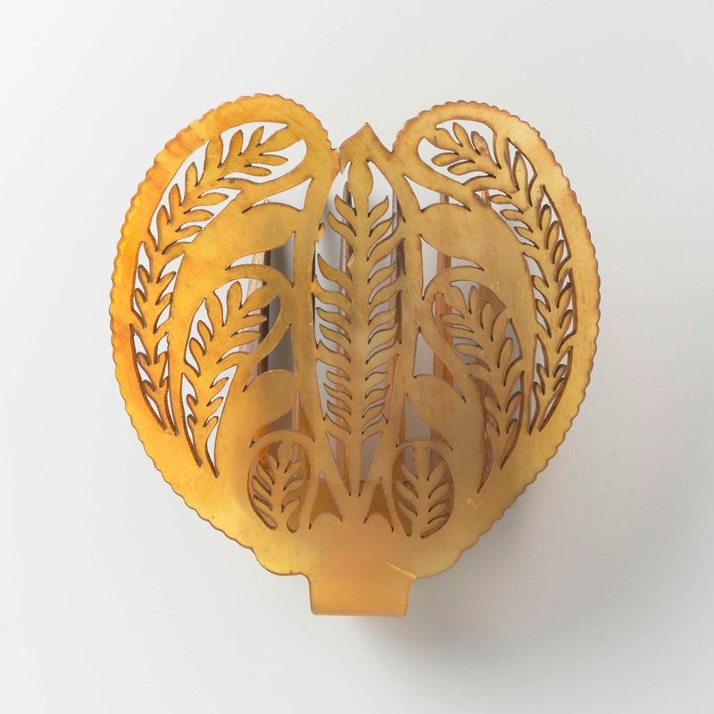 Arte decorativo que presenta un peine de cuerno con seis dientes de Unknown Artist