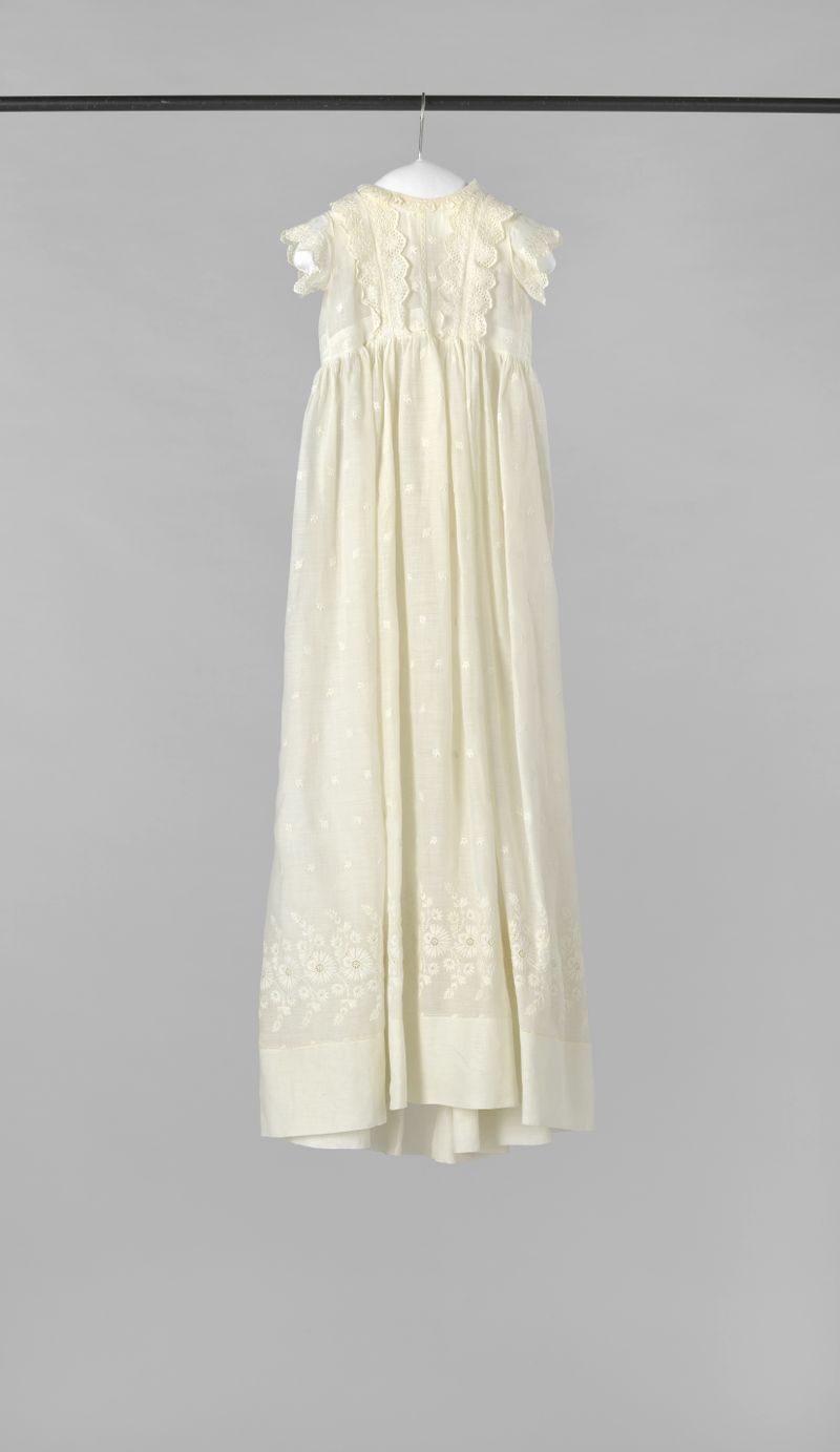Roupa têxtil para bebê de Unknown Artist com bordados de flores de milho e rosas.