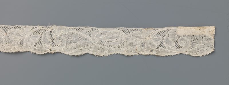 Obra de renda com uma flor em forma de palmeta em um longo caule curvado de um artista desconhecido
