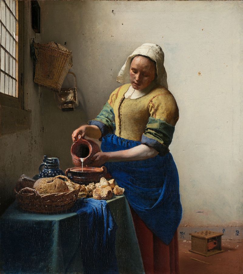 The Milkmaid by Johannes Vermeer, oil on canvas, shows a maidservant pouring milk in a bright interior.