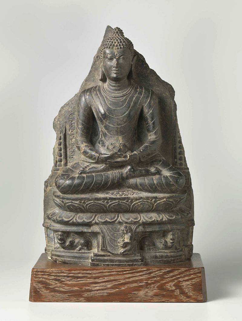 Escultura em pedra de Buda por artista desconhecido, retratando serenidade e meditação.